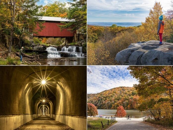 A collage of four images showcasing attractions in Somerset County, Pennsylvania. The top left image features a fisherman by a creek in front of a picturesque red covered bridge surrounded by autumn foliage. The top right photo shows a person standing on a rocky outcrop overlooking a vast landscape of colorful fall trees under a clear sky. The bottom left picture captures a well-lit tunnel with multiple lights creating a starburst effect. The bottom right image is a tranquil scene of a park with a bicyclist on a path next to a lake reflecting the vibrant autumn trees and blue sky.
