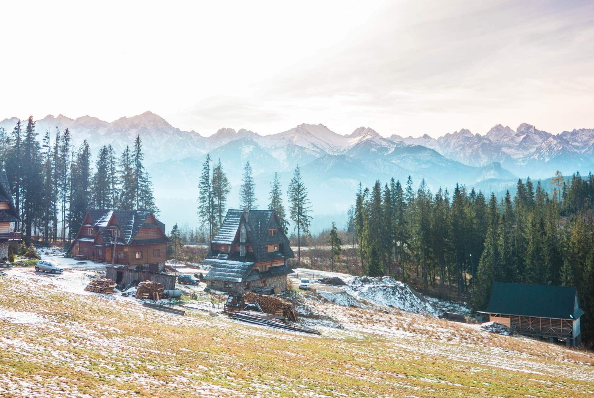 Traditional houses outside Zakopane in southern Poland surrounded by a mountainous landscape.