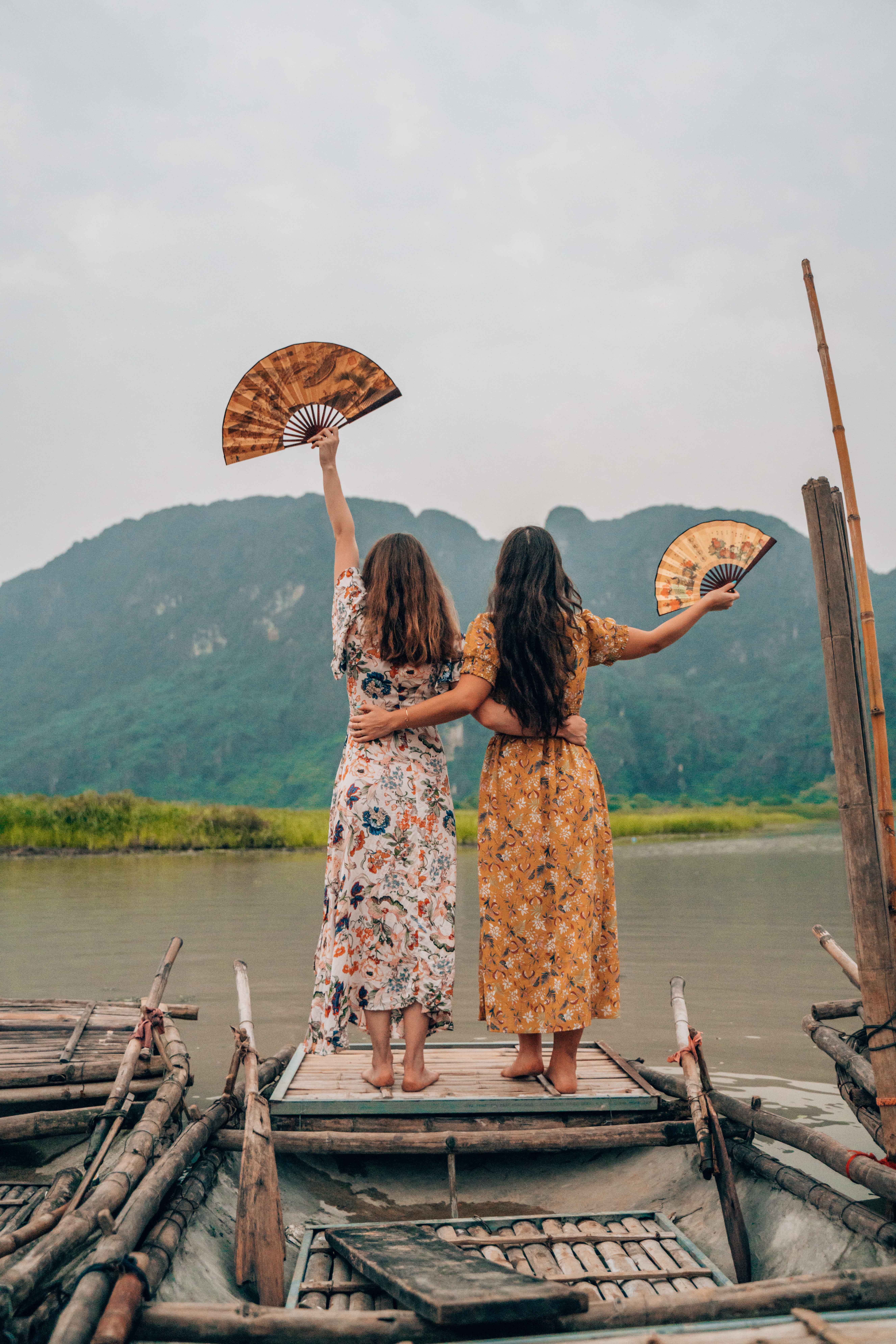 Standing on top of a bamboo canoe in the river