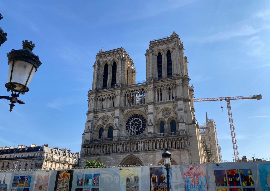 Notre Dame front with wall and drawings and lamp post