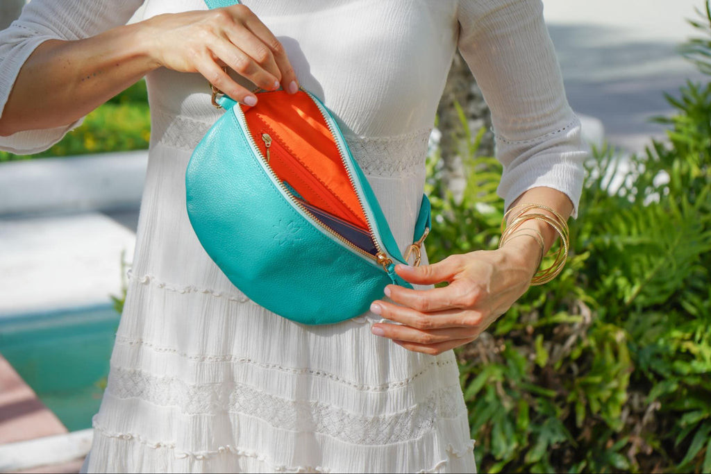 Turquoise crossbody bag with gold detailing, perfect for secure travel