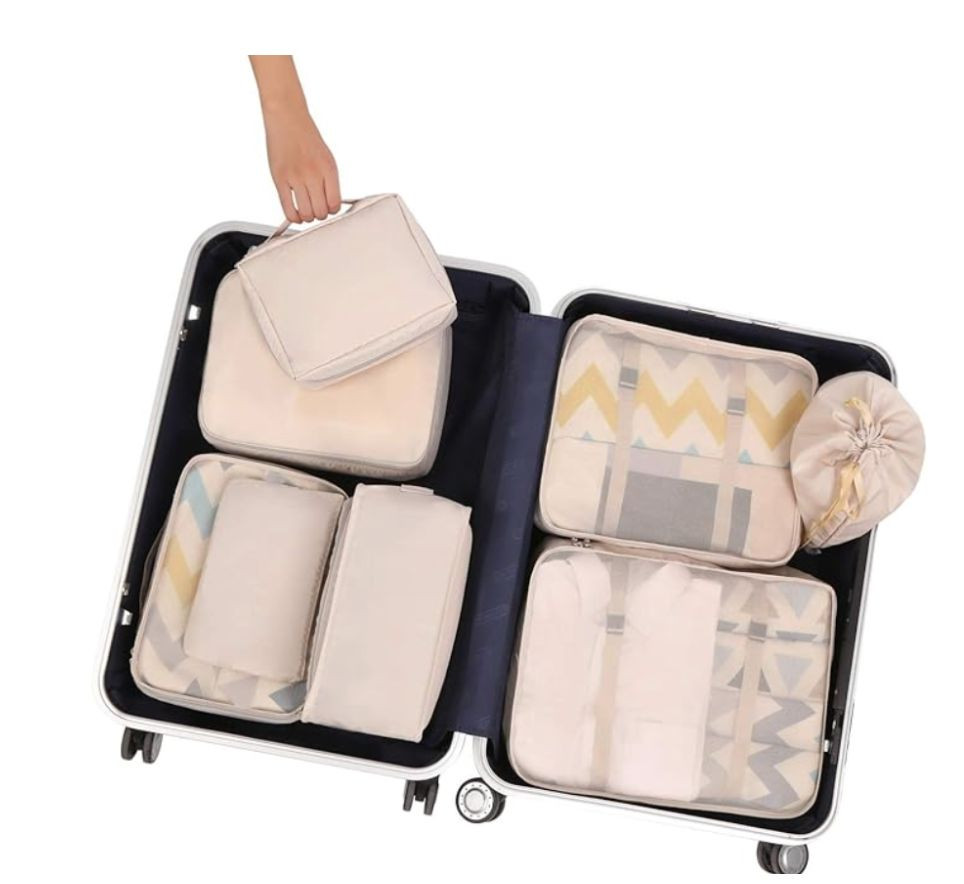 Open suitcase showcasing organized packing cubes in cream color