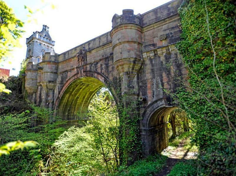 Overtoun Bridge, framed by lush greenery, stands as a stark reminder of its unsettling reputation as &quot;The Bridge of Death&quot; for dogs, adding a mysterious allure to the Scottish landscape.