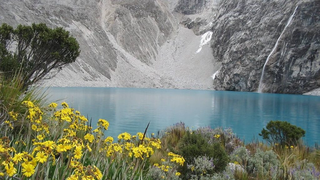 Turquoise waters of Lake 69 in the Cordillera Blanca, surrounded by towering peaks. A popular hiking destination in Huaraz.
