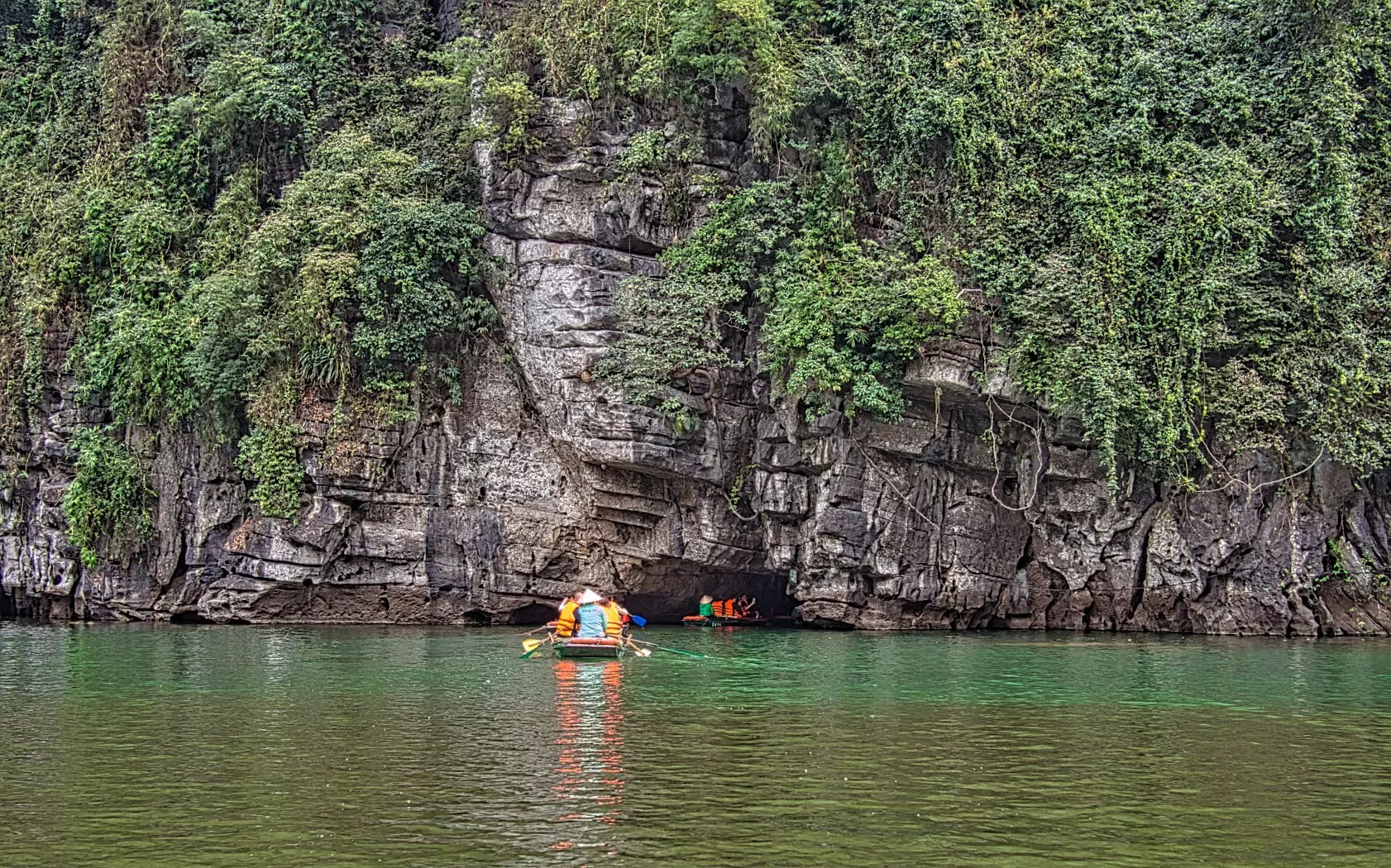 Boats heading to a cave along the Trang An River in Vietnam