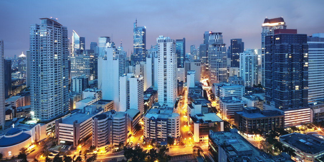 Manila, Philippines. The city is vibrant and bustling, with many buildings and a blue sky