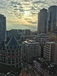 View from the top of the Boston Custom House, showcasing the harbor and city skyline under a clear winter sky.
