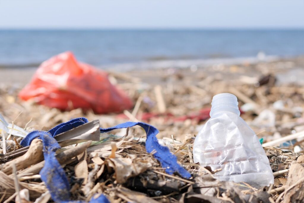 Plastic waste and trash on sandy beach environmen showing the importance of beach cleanups