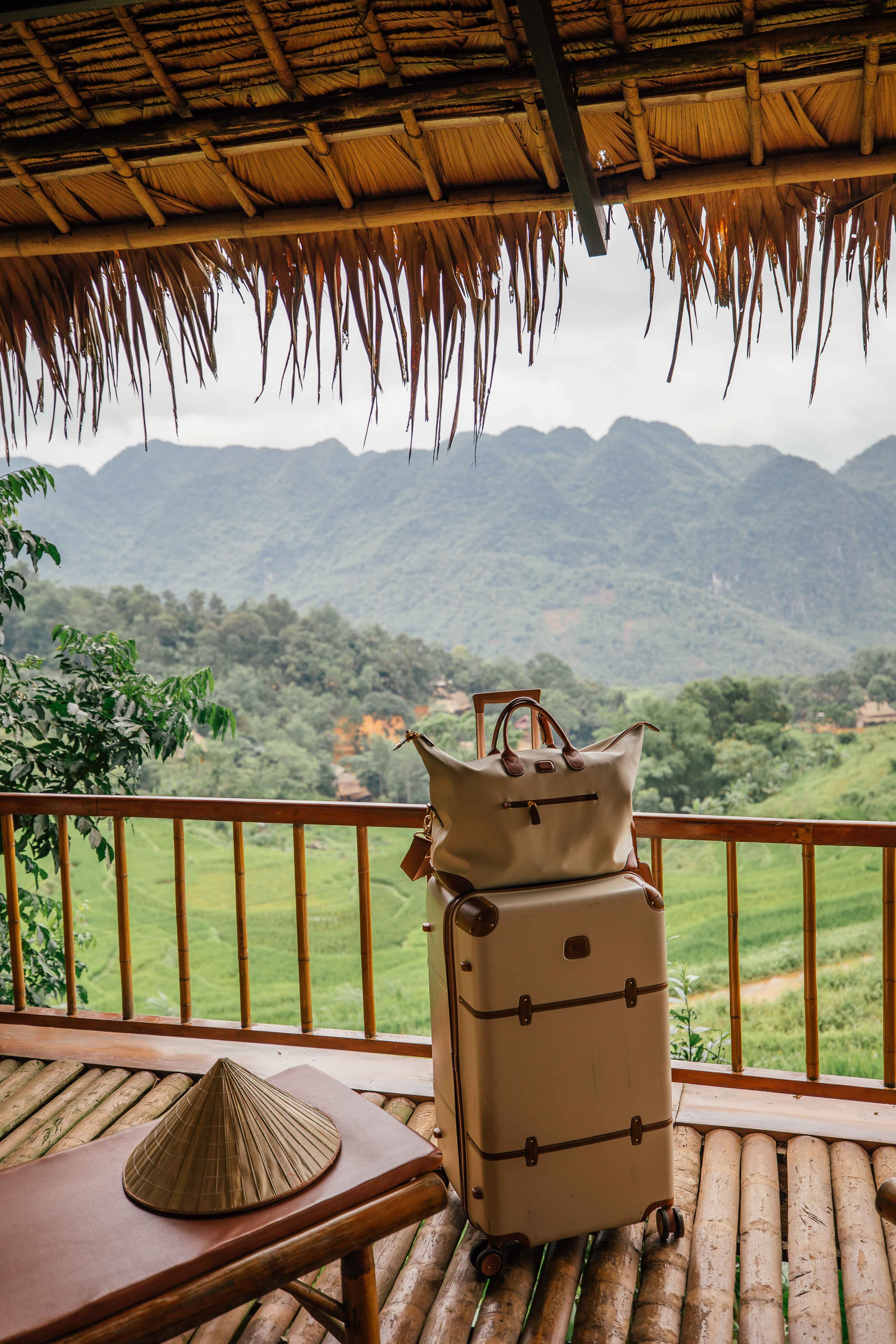 Suitcase luggage sitting on the hotel balcony overlooking the rice terraces and mountains