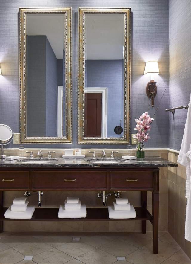 Upscale hotel bathroom featuring a spacious double mirror and luxurious amenities