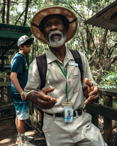 A guide pointing out wildlife during a tour, emphasizing the educational aspect of guiding in environmental tourism.