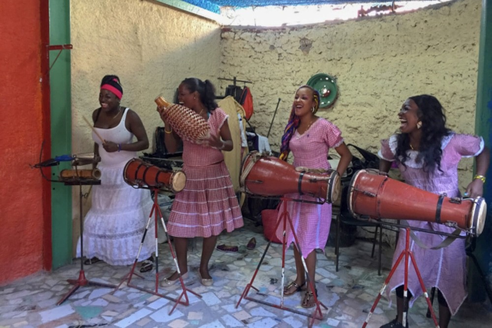 A rumba band dancing and playing music on their conga drums in Cuba.