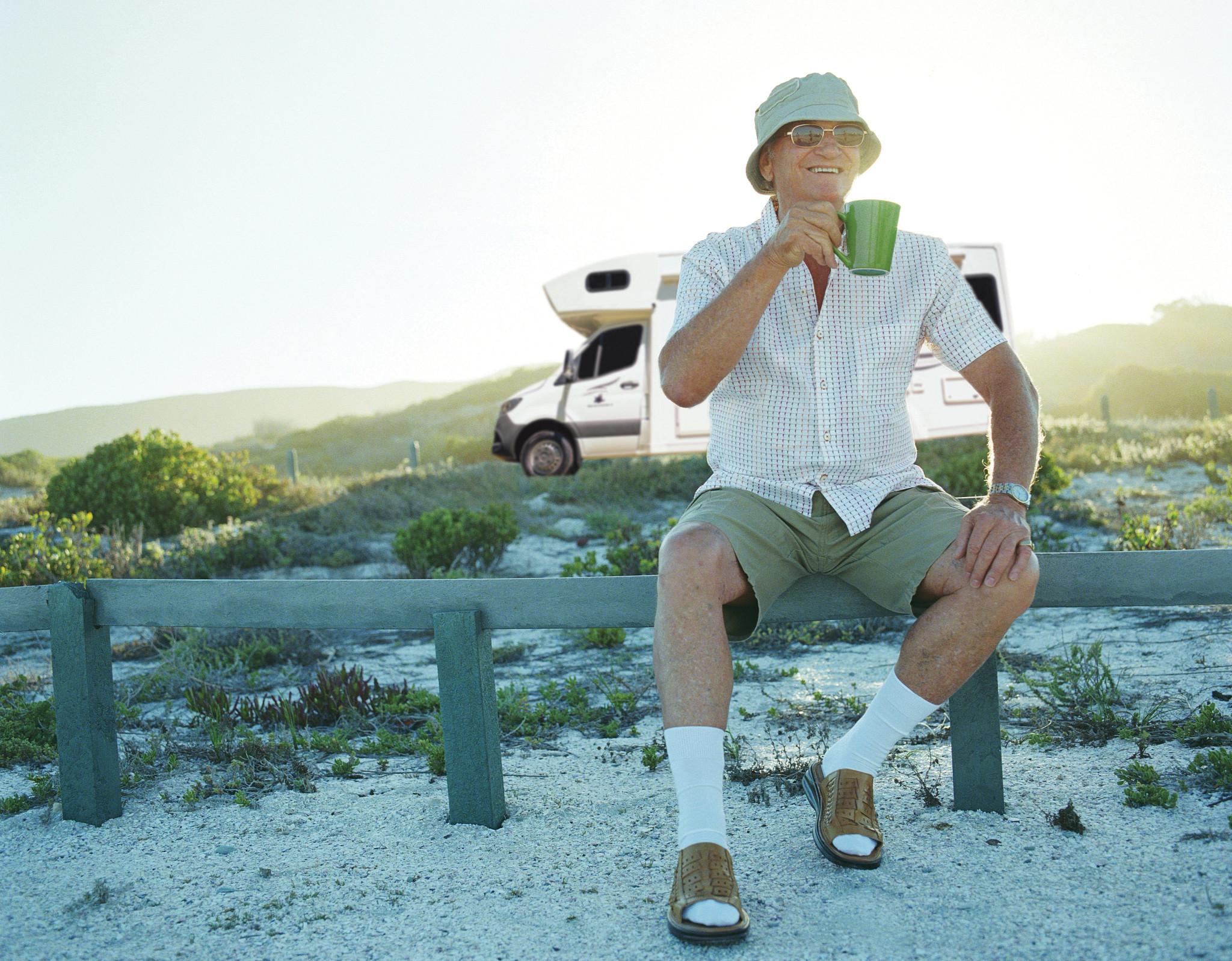Senior man with a mug in front of a RV Super Centre camper