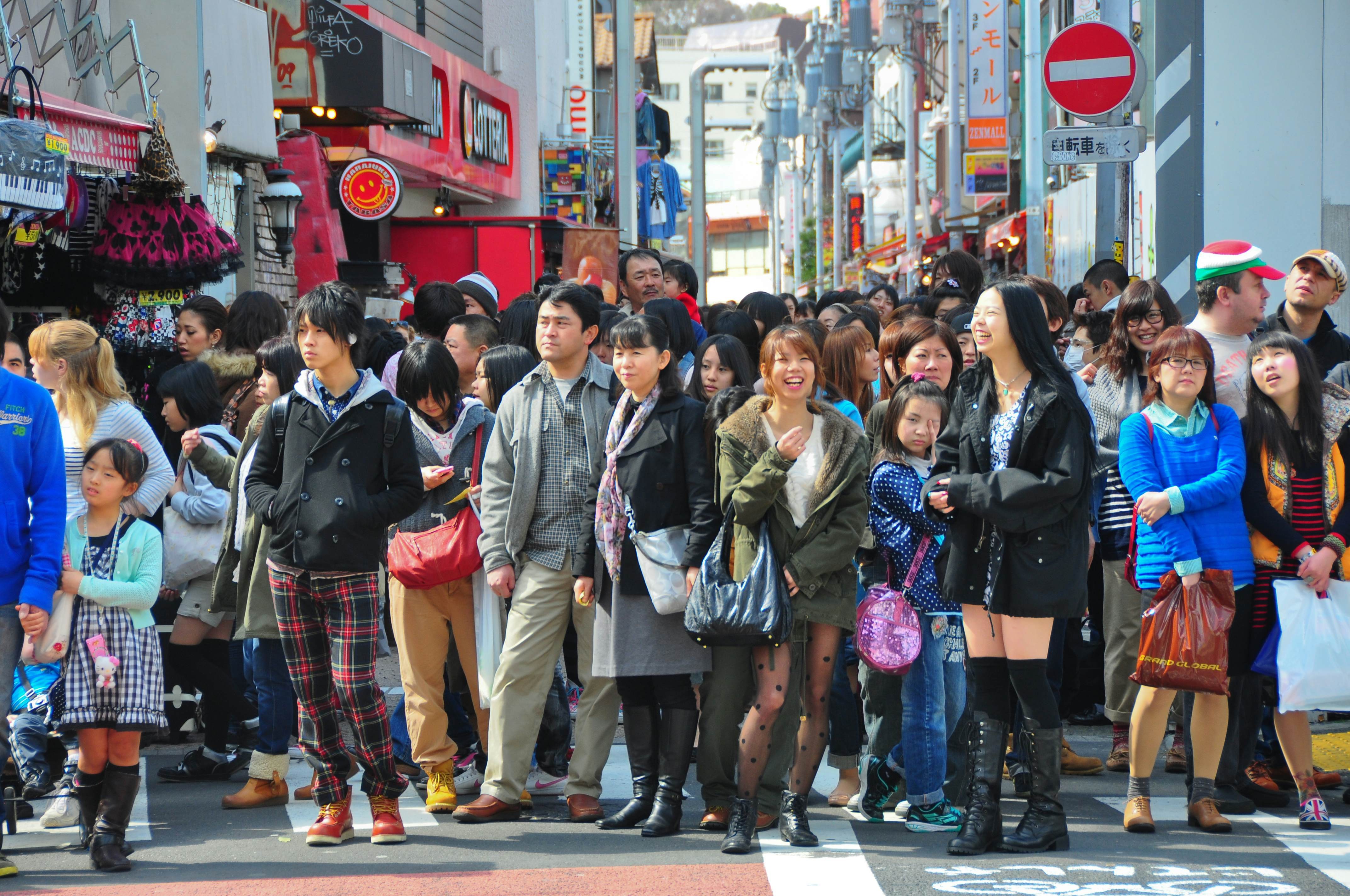 People, mostly youngsters, wait to cross a road in a busy city: Crowds in Harajuku, Tokyo