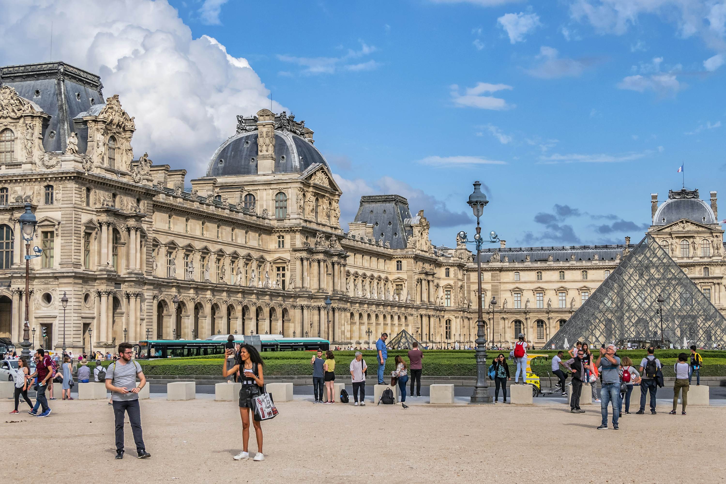 Visitors crowd around the Louvre