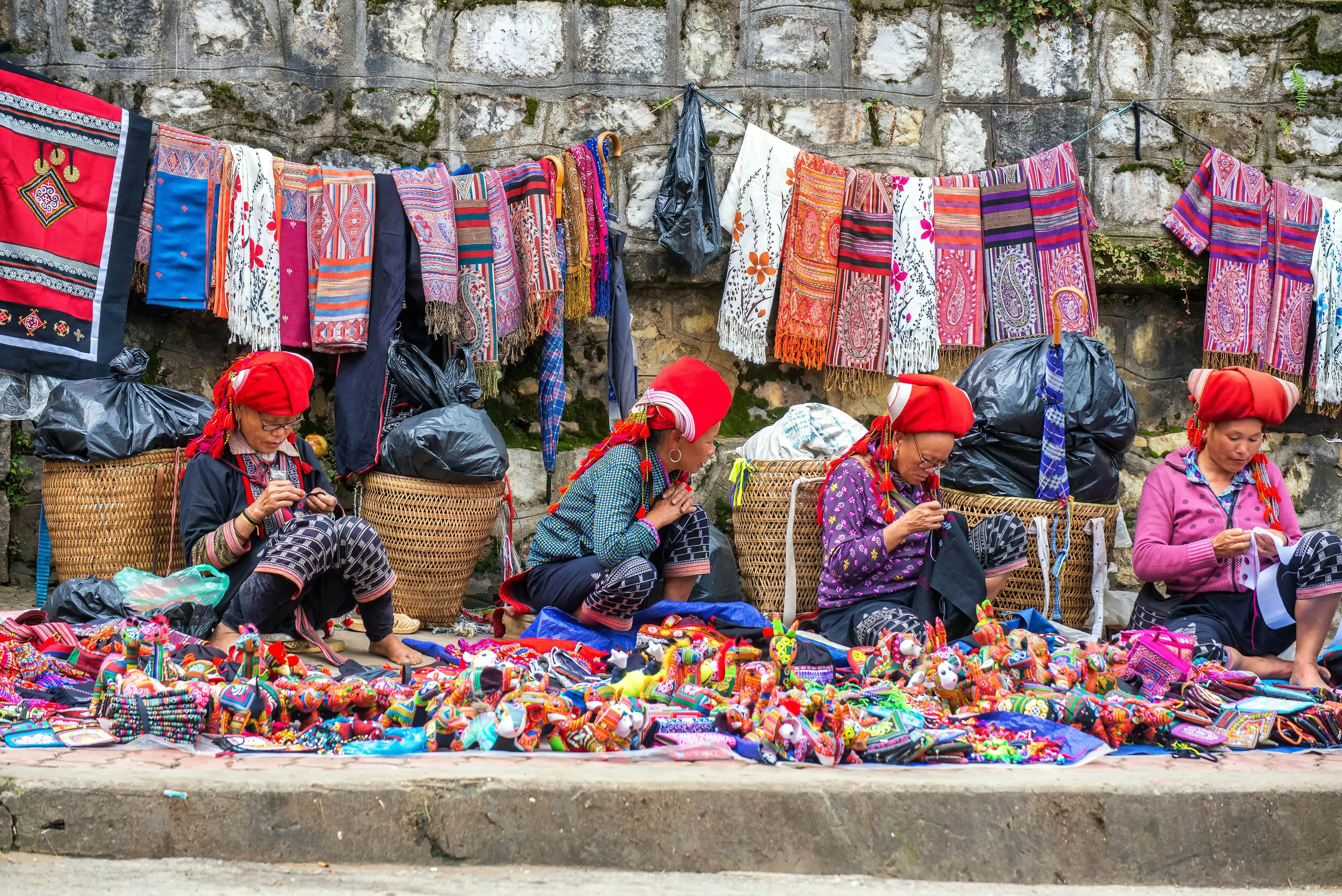 Hmong women sell traditional handmade goods on the main street in Sapa, Vietnam