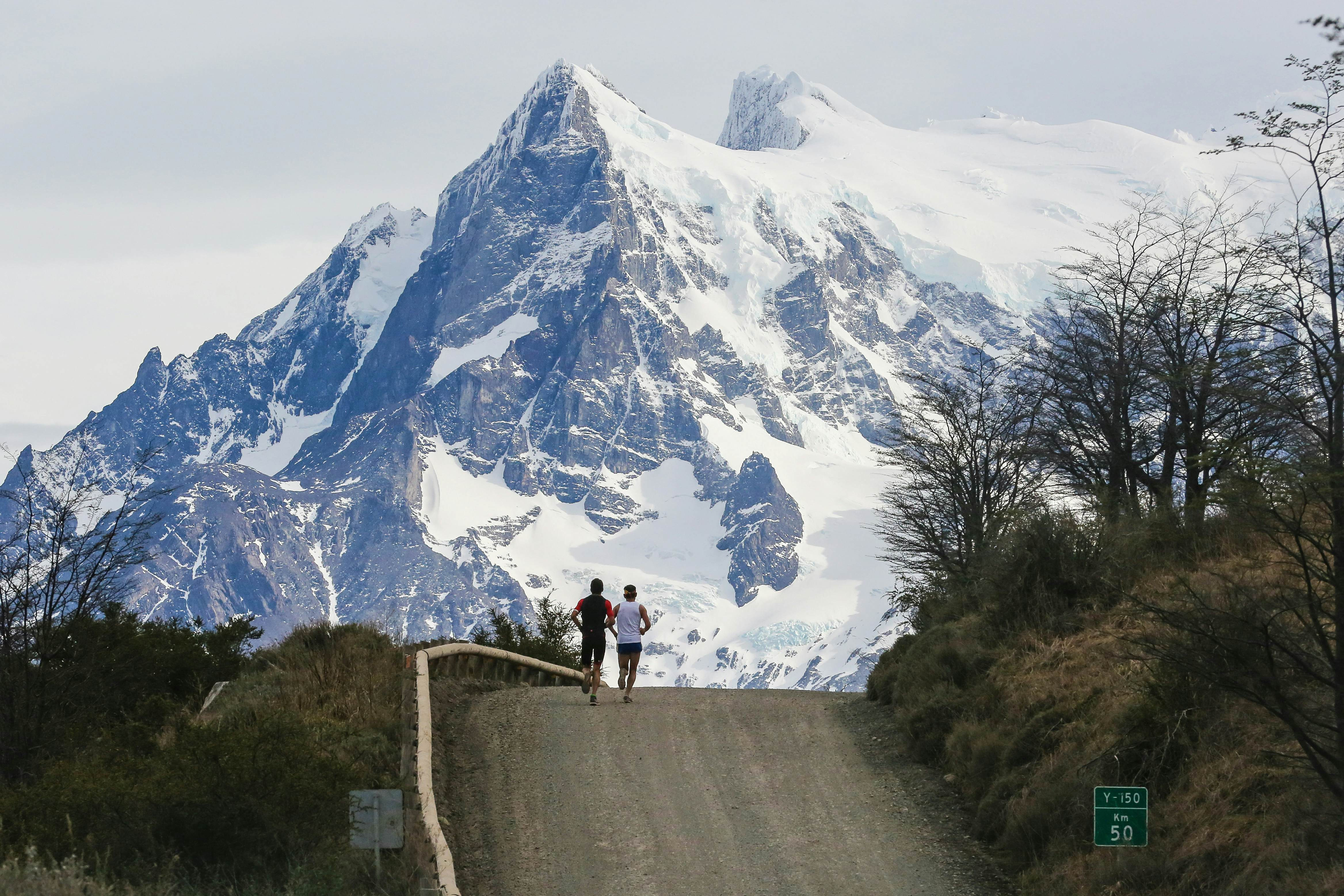 Runners competing in the Patagonian International Marathon with snow-capped mountains in the background