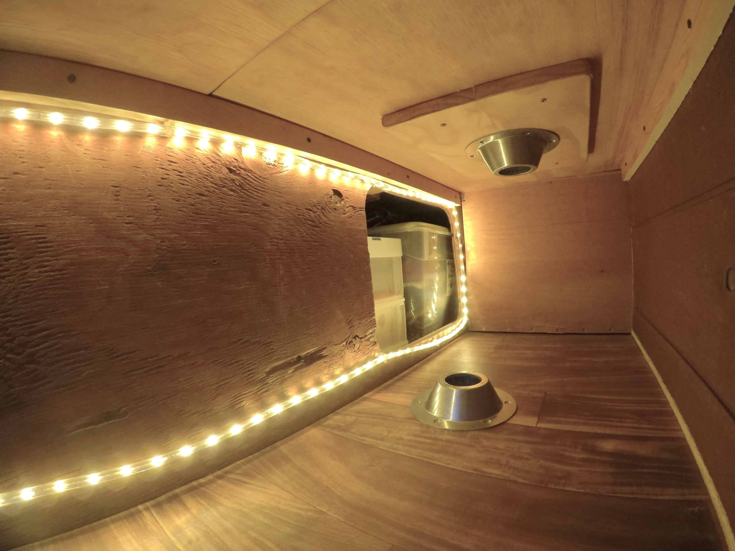 Under-bed storage opening in a van conversion