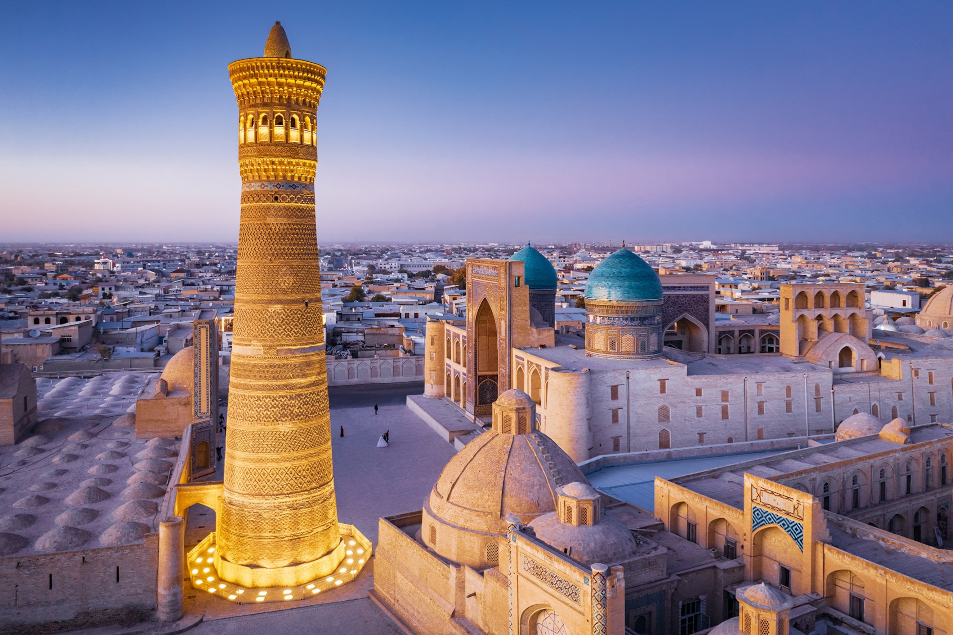 The roof of the Mir-i-Arab Madressa and Kalyan Minaret in Bukhara, Uzbekistan lit up by the sun setting.