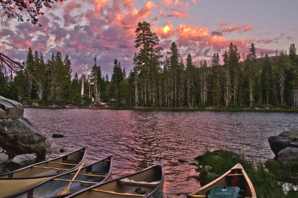 Canoes on a lake at sunset, showcasing the peaceful beauty of Plumas County's best lakes