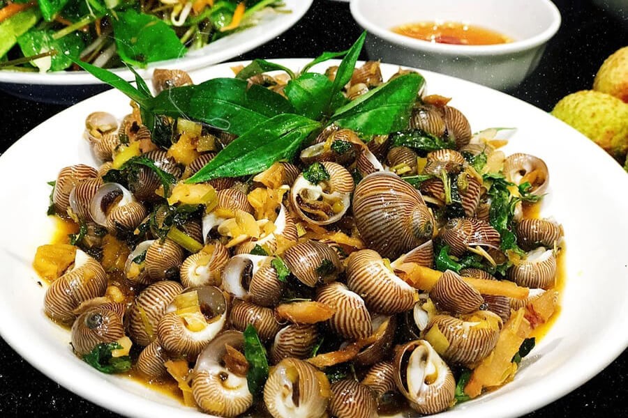 Stir-fried Snails with Soya Sauce (Oc xao tuong), a popular and affordable street food snack in Ha Long Bay