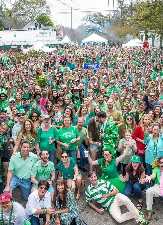 A large crowd dressed in green celebrating St. Patrick's Day on city streets
