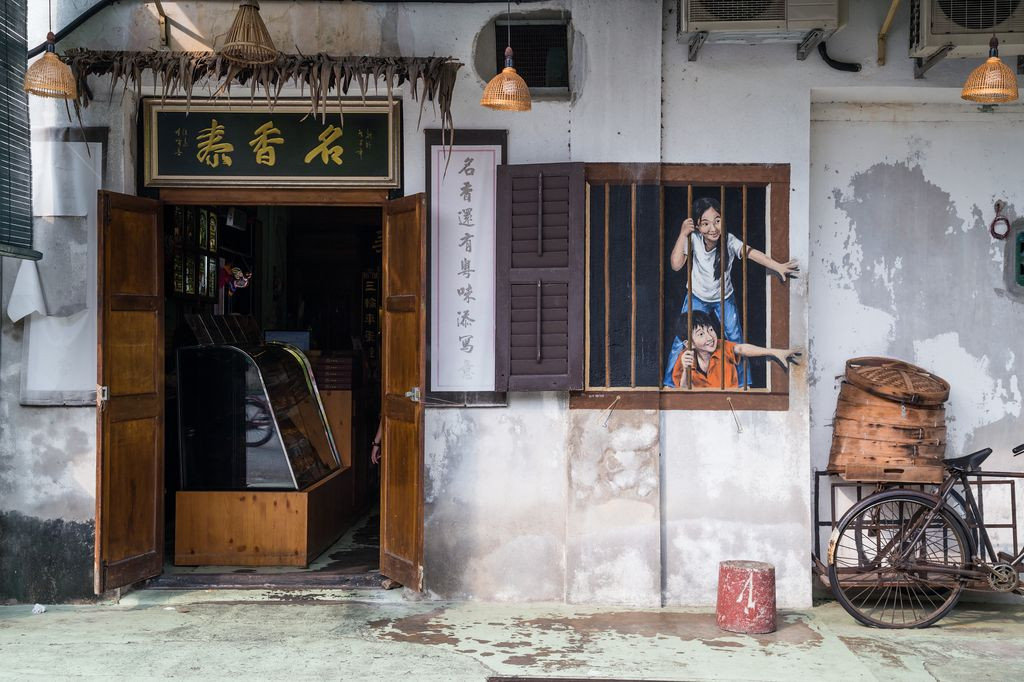 Wall art of two children reaching out from a window in Georgetown, Malaysia