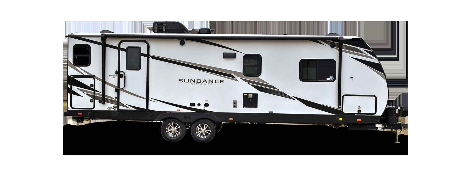 A double-axle Heartland Sundance travel trailer parked in a serene outdoor setting.