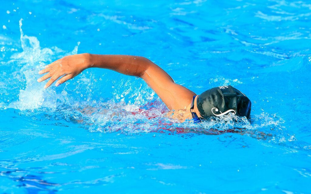 A dynamic view of swimmers competing at the Commonwealth Games, with the focus on their strokes and competitive spirit in the sports in Scotland.