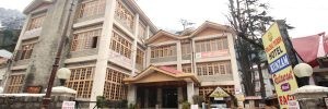 The Orchard Huts Manali with a backdrop of lush greenery and clear skies