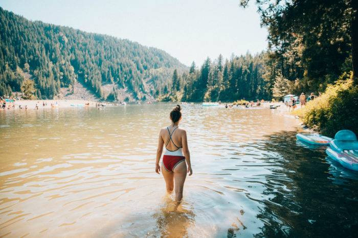 Woman wading in Lake Pend Oreille at Farragut State Park, Northern Idaho.