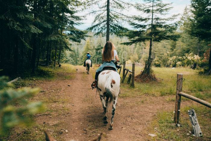 Woman riding horse at Western Pleasure Guest Ranch, Northern Idaho.