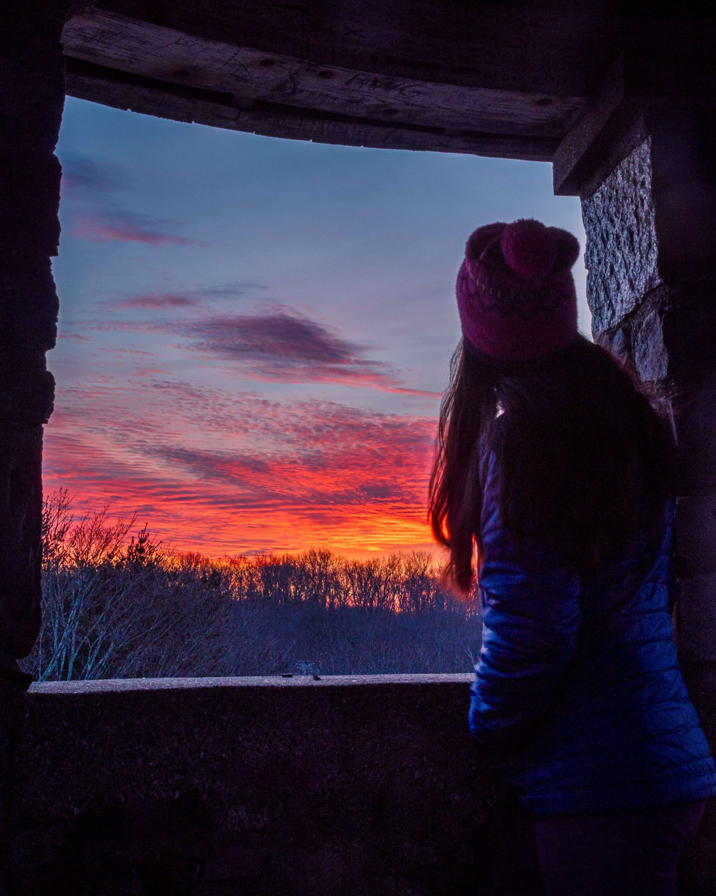 woman looking out of camp columbia tower at sunset time in litchfield connecticut