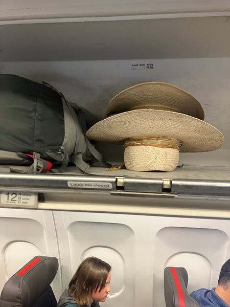 Hat safely stored in an overhead compartment