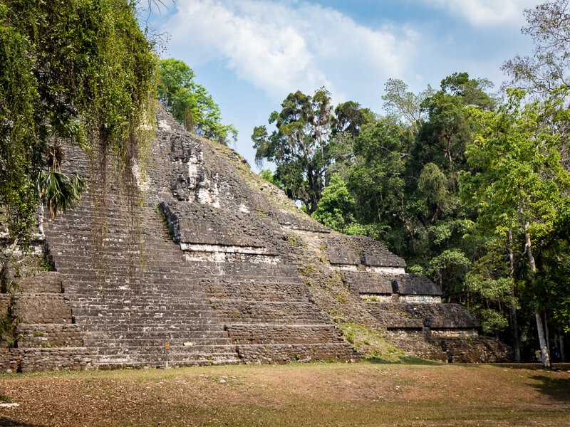 A Mayan pyramid overgrown with vegetation in Tikal, a place you shouldn
