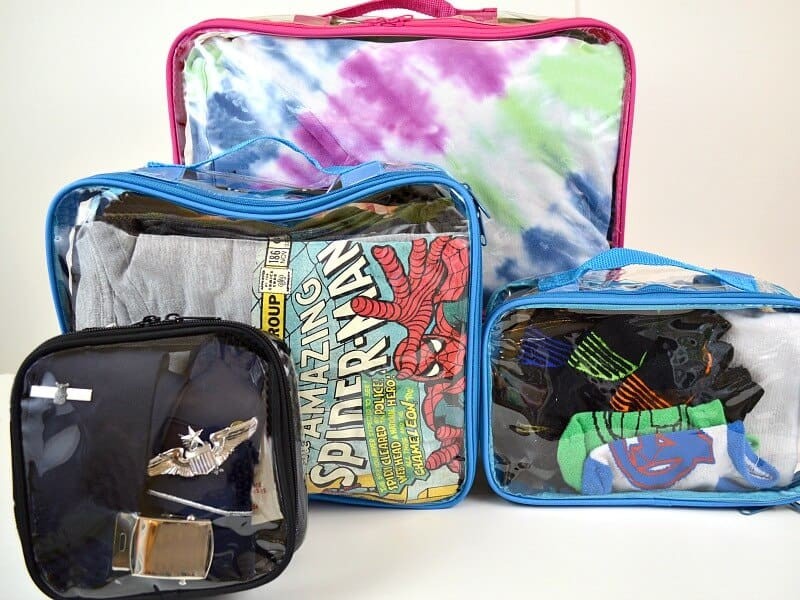 Various sizes of clear packing cubes neatly organized in a suitcase for travel.