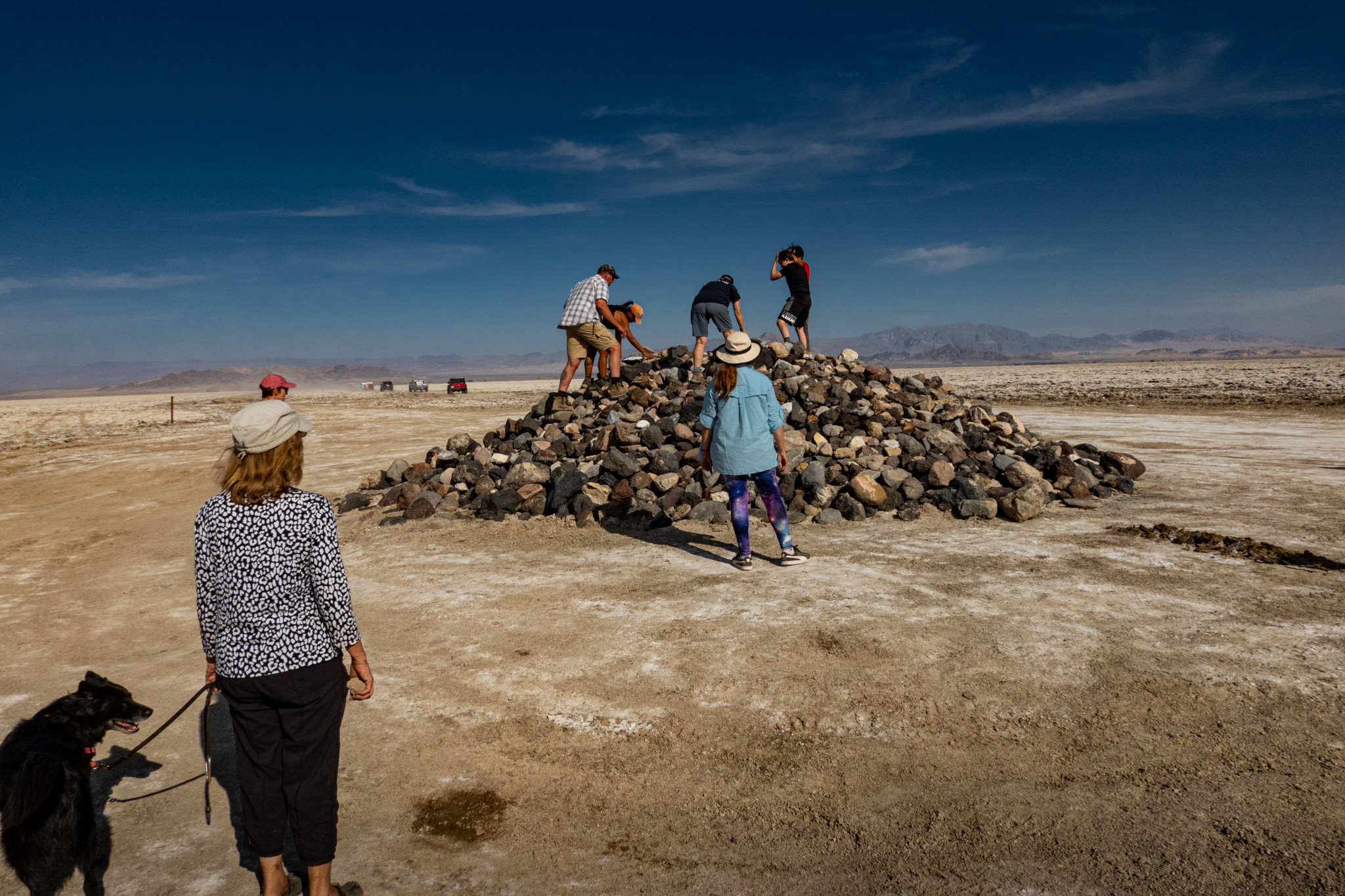 Group of travelers gathered at the Travelers Monument, adding rocks to the pile