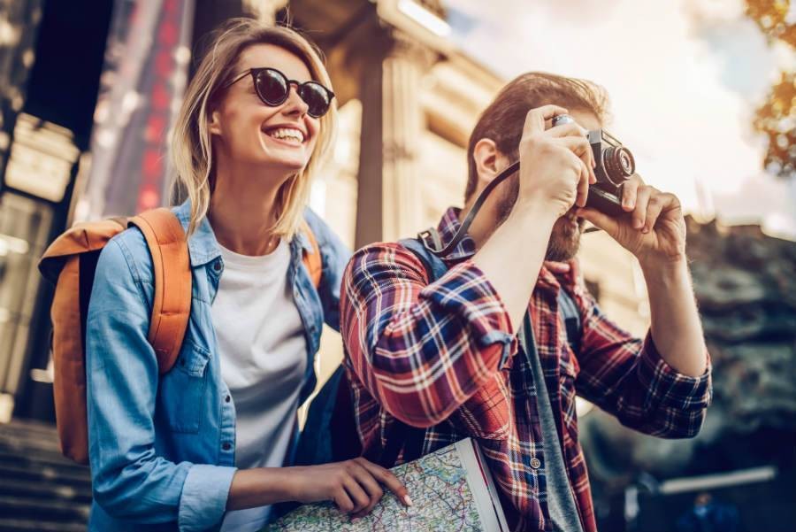 A travel couple taking photos outside of a museum