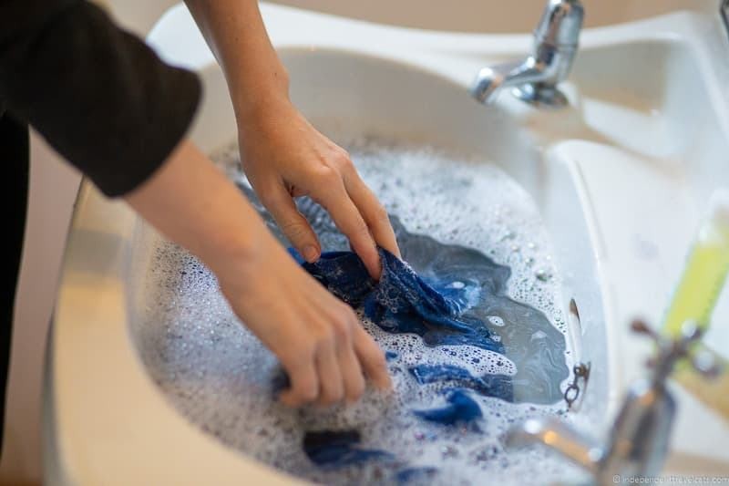 Hand washing clothes during travel, showcasing travel laundry tips