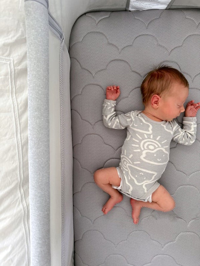 Baby Sleeping Peacefully in a Portable Bassinet