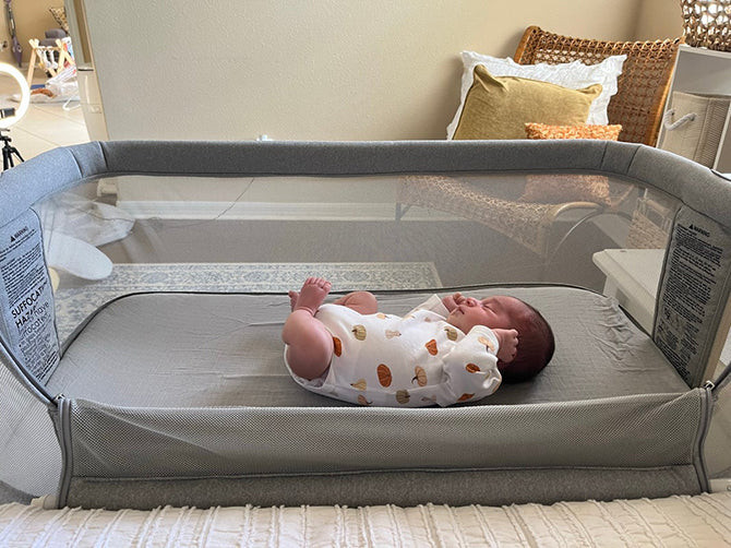 baby sleeping in a breathable travel bassinet