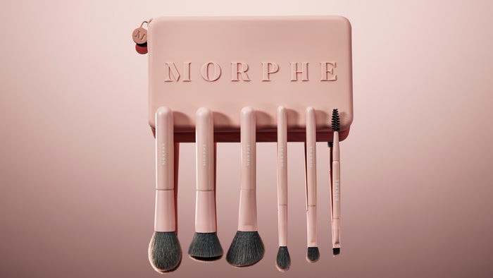 Organized makeup brushes in a roll-up case, showing individual compartments for each brush.