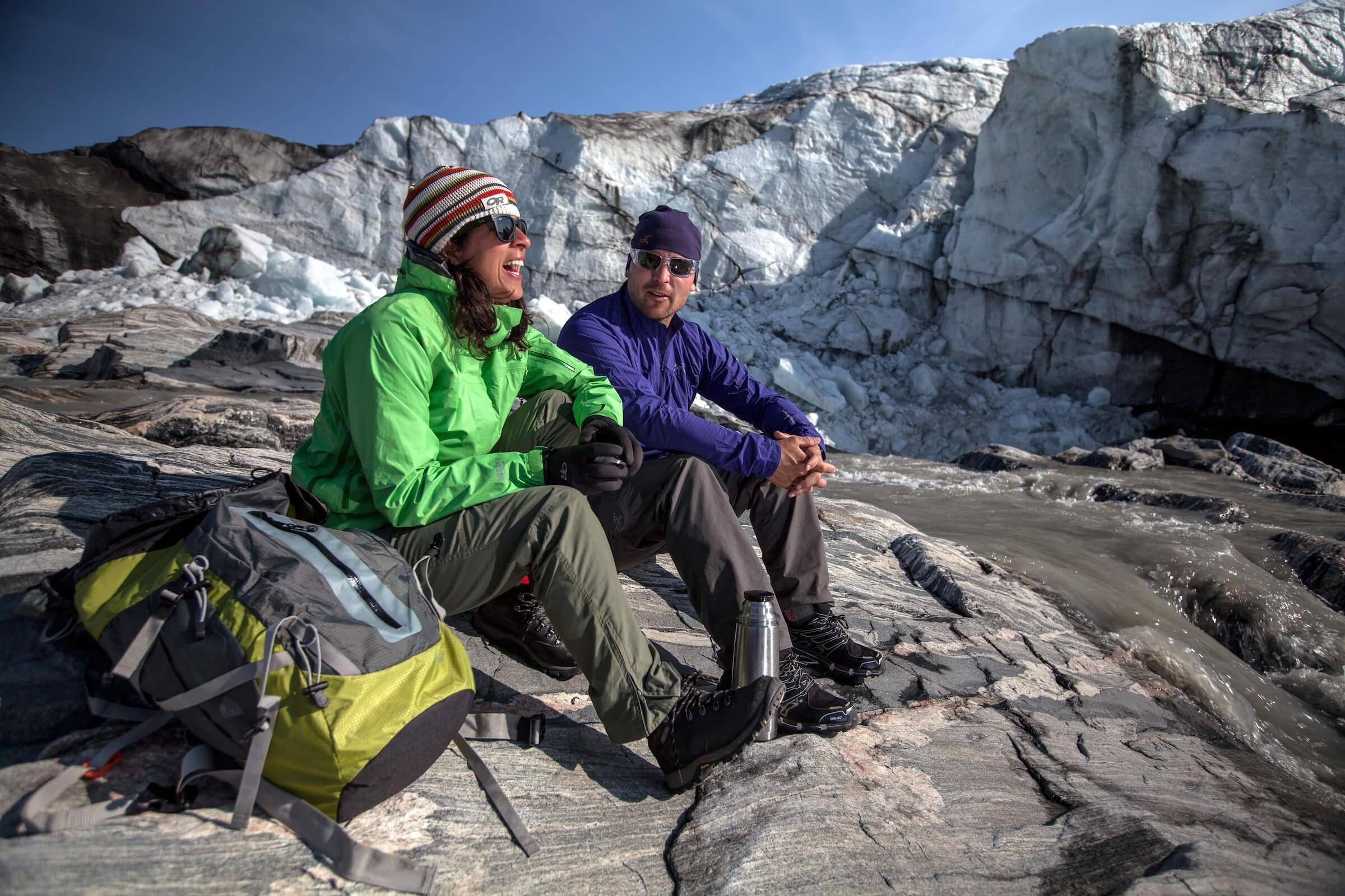 Hikers enjoying the sun by Russell Glacier near Kangerlussuaq, Greenland, showcasing a perfect day for Arctic exploration