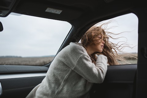 Woman sitting in car looking out window