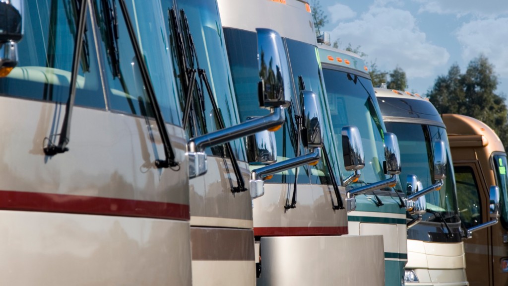Row of Class A RVs for sale on a dealership lot