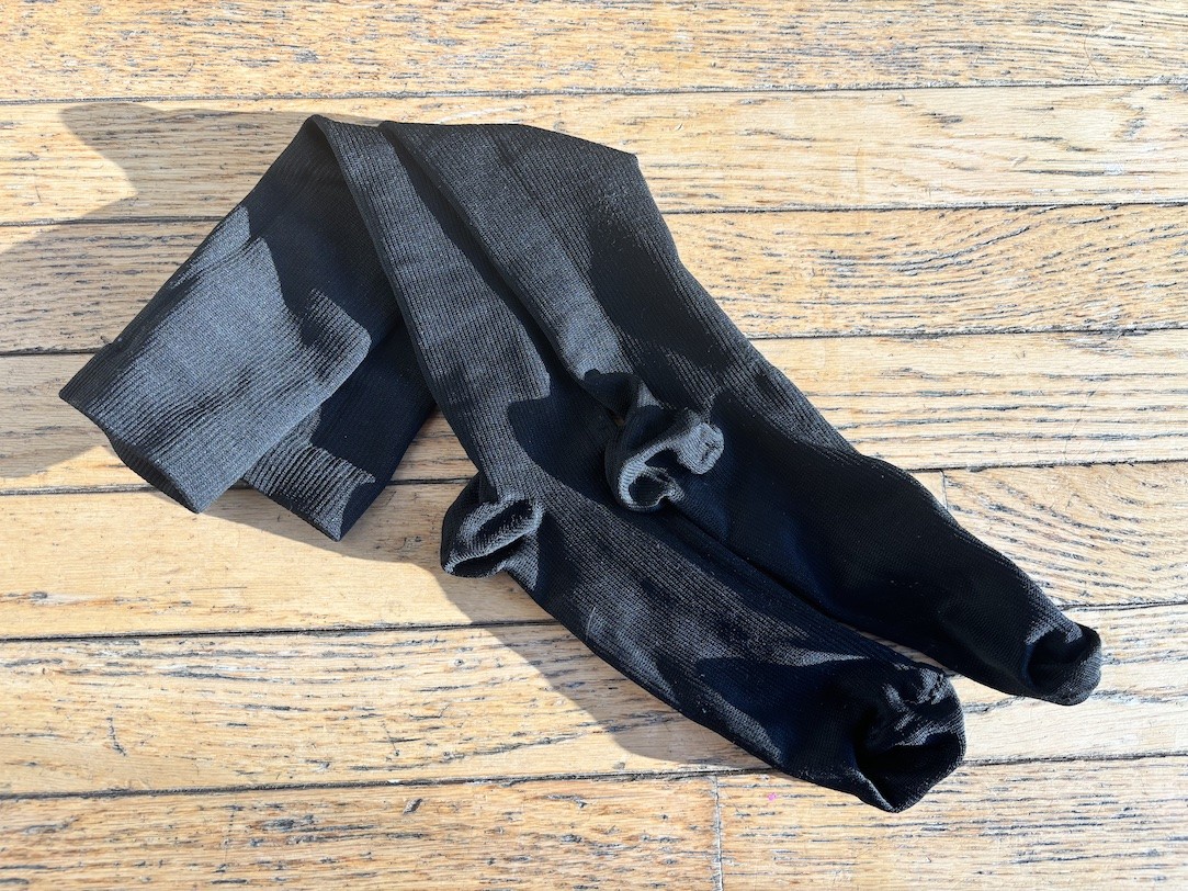 A pair of compression socks on a hardwood floor.
