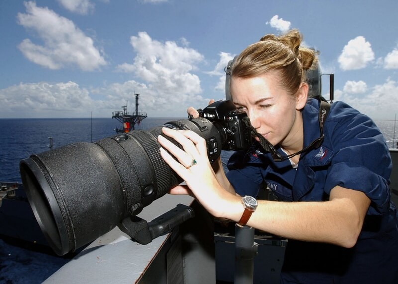 Sabrina Day with a massive 400mm telephoto lens aboard an aircraft carrier