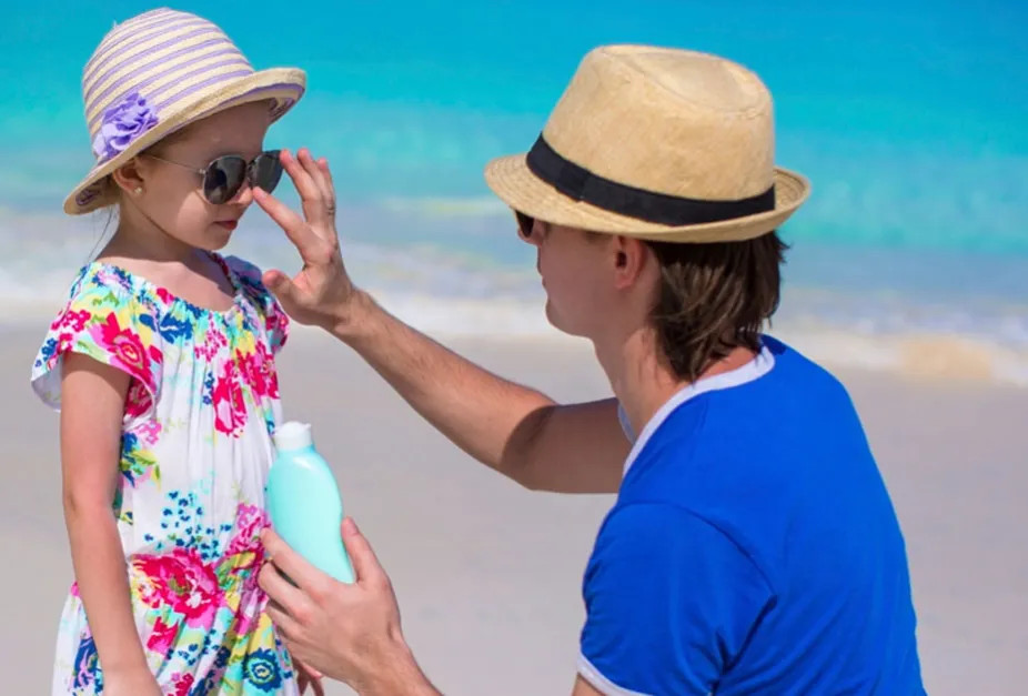 photo of a parent applying sunscreen to protect a child
