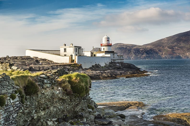 A tourist using a tablet to access information about a lighthouse, showcasing how technology can enhance the visitor experience