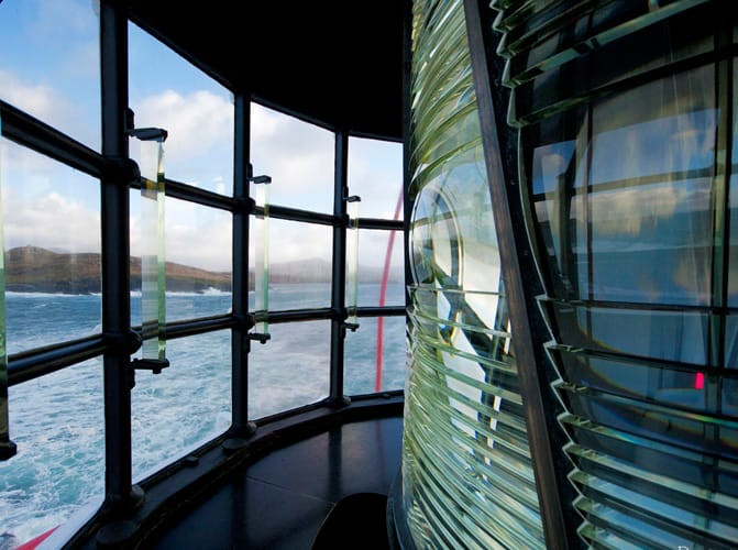 Visitors enjoying the view from a lighthouse, showcasing its architectural beauty and stunning coastal location